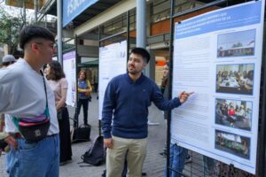 Esttudiante explicando un poster académico